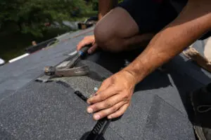 Nailing in shingles during a storm damage roof repair