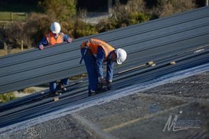 two men working on a commercial roof